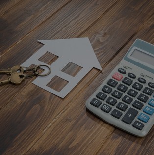Image of a house and keys sit next to a calculator.