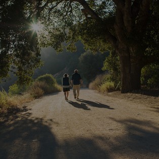 Senior couple walking through a forest trail.